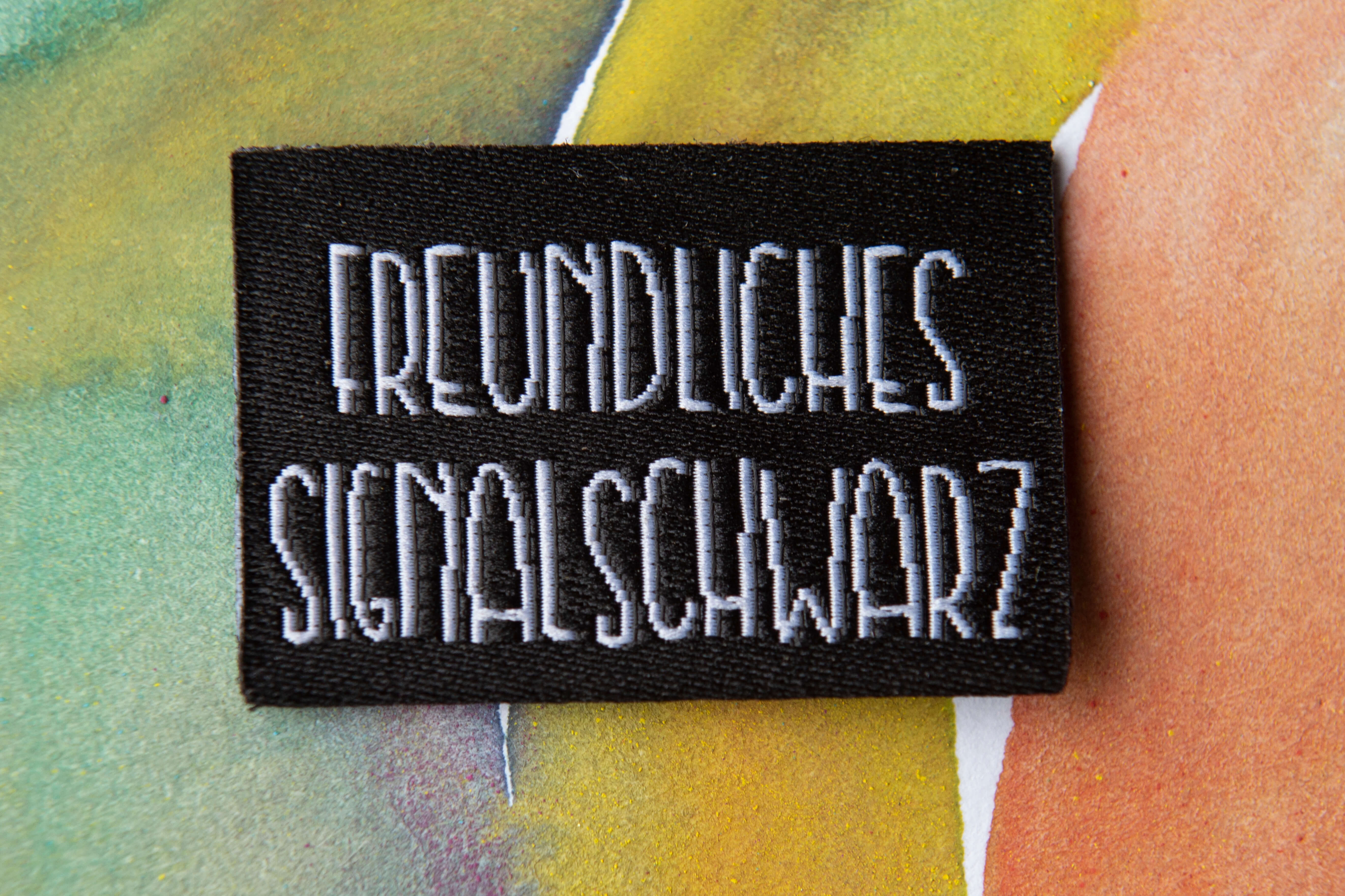 webetikett-zum-einnähen-signalschwarz Webetikett zum Einnähen "Freundliches Signalschwarz" aus recyceltem Polyestergarn